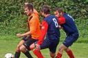 LET'S WALK THE WALK: Poppleton United striker Ben Brannigan (orange shirt) leads the way against Harrison Signs Picture: Nigel Holland