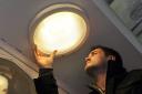 Tom Holmes from St Michael le Belfrey Church changes a light bulb for a neighbour