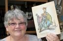 Pauline Ensor, a volunteer at the Oxfam shop in Petergate, with a Christmas card from the Redgrave  acting dynasty, which was found being used as a bookmark
