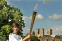 16-year-old Scott Stockdale posing with the Olympic Torch on the bar walls