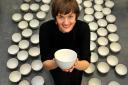 Artist Clare Twomey amongst some  ten thousand ceramic bowls that  will be piled up high to create an spectacular installation at of pots inside York Art Gallery and will be made by York College Art & Design students