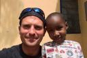 Travis Young,  39, with one of the orphans at the Kilimanjaro  Orphan Centre