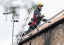 A firefighter on the roof of the         blaze-hit flats