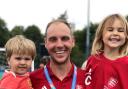 Alex Cockram wearing his gold medal with his children, Oscar and Rosie