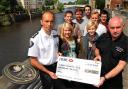 Friends of Richard Horrocks look on as a cheque for more than £1,000, raised from their naked calendar, is presented by Chloe Bowman, left front, and Abbi Horrocks, right front, to York Fire Station manager Paul Bennett and firefighter Paul Warnock
