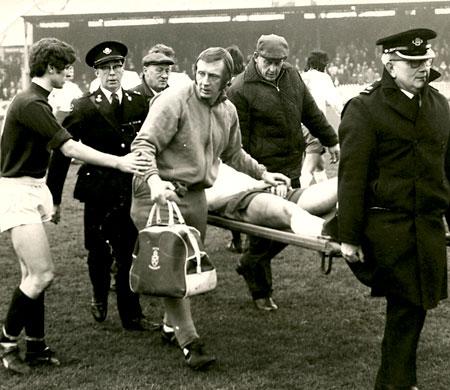 01/01/72 - York City 0, Bolton Wanderers 0: City's fullback Phil Burrows offers his apologises to the Bolton trainer as defender Paul Hallows is carried off after he and Burrows had a clash of heads at Bootham Crescent.