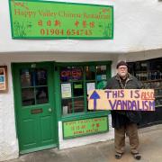 Gordon Campbell-Thomas with his sign protesting outside the Happy Valley Chinese restaurant in Goodramgate, York Image: Haydn Lewis