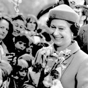 A happy Queen accepts flowers from crowds during her 1983 visit