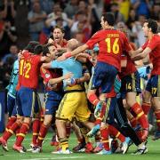 Cesc Fabregas (third left) is mobbed by his Spain team-mates after netting the decisive penalty