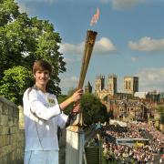 16-year-old Scott Stockdale posing with the Olympic Torch on the bar walls