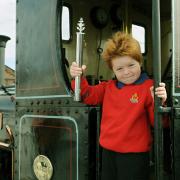 Six-year-old Charlie Holtby, of the Boys' Brigade 1st Acomb Company, holding the Baton, during the handover at the National Railway Museum, on the footplate of steam locomotive Lilla