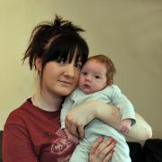 Charlene Farah-Price with her baby son,Thomas, at her flat in Lindsey Avenue