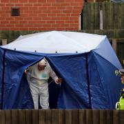 An officer leaves the forensic tent at Burnholme Grove today.
