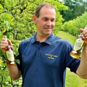 Cameron Smith with bottled cider in the apple orchards at Ampleforth College