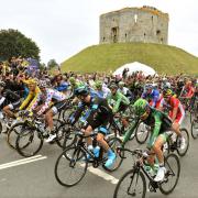 Riders pass Clifford's Tower in York earlier today