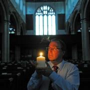 St Michael le Belfrey administrator Mark Rance lights a candle to mark the 100th anniversary of the start of the First World War