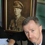 Paul Feehan, director of music at Bootham School, has composed a requiem mass to commemorate the outbreak of The Great War in 1914. Behind him is a portrait of Eric Busvine, killed at the battle of Ypres
