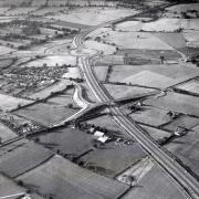This  view of the A64 York by-pass in August 1981 shows the Stockton-on-the-Forest road bridging the carriageway, the intersection with the Malton Road, centre, and the small hamlet of Hopgrove, on the left
