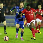 Femi Ilesanmi (R) of York races Sean Rigg for the ball during the FA Cup first-round replay between AFC Wimbledon and York City at Kingsmeadow Stadium, Kingston on Nov 18, 2014