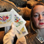 Helen Thornton, documentation assistant (history) at York Museums Trust, with some of the hand-made silk cards which were sent home from the front by soldiers during the First World War
