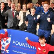 CHEERS: Burton Green pupils Kleo Falcone, left, and Kaiden Butler join York City chairman Jason McGill, Paula Stainton and staff at York City Foundation after they were given charitable status