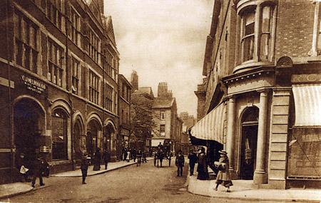 Davygate around 1903. On the left is a building erected in 1881 by CJ Melrose for his wine and spirt business. On the right is the aptly-named tailor's shop called R. Cutter.
