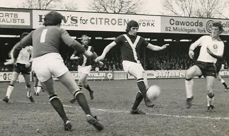 10/04/76 - York City 3, Plymouth 1: York City centre half Steve James kicks clear from the foot of Plymouth striker Bill Rafferty in the game at Bootham Crescent. Other City players in the picture are Graeme Crawford and Derrick Downing.