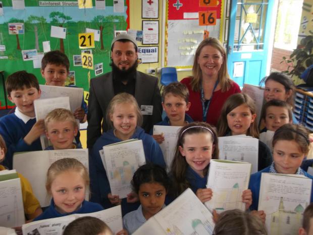 Head teacher Cath Precious with Imam Abid Salik and some of the children with their drawings