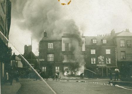 Dramatic image of what was Walpamur paint merchants in St Sampson's Square ablaze around 1929.  The pub on the right is The Three Cranes.