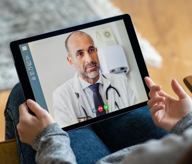 A doctor carries out a virtual consultation with a patient
