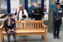 Veteran Ken cooke sits on the new bench while it is blessed by Fr Romani