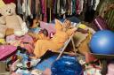 Stacey Solomon sits among a family’s possessions in the BBC show Sort Your Life Out. Picture: PA .