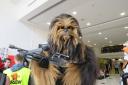 Chewbacca poses with a massive blaster at York Comic Con
