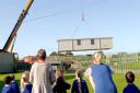 Westfield Primary School pupils watch as a              temporary           classroom for York High School pupils is lifted into place