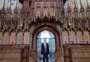 Adam Wilson, York Minster's Assistant Organist, in front of the minster's Grand Organ pipes