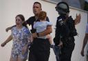 Israeli police officers evacuate a family from a site hit by a rocket fired from the Gaza Strip, in Ashkelon, southern Israel, on Saturday October 7