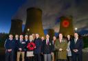 The illuminated poppy at Drax Power Station with veterans  from the station who organised its Poppy Appeal