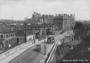 A car and a tram passing over the Queen Street Bridge in about 1920