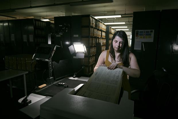 York Press: Laura Gowing, a Findmypast technician, scanning individual pages of the 30,000 volumes of the 1921 census (Mikael Buck/Findmypast/PA)