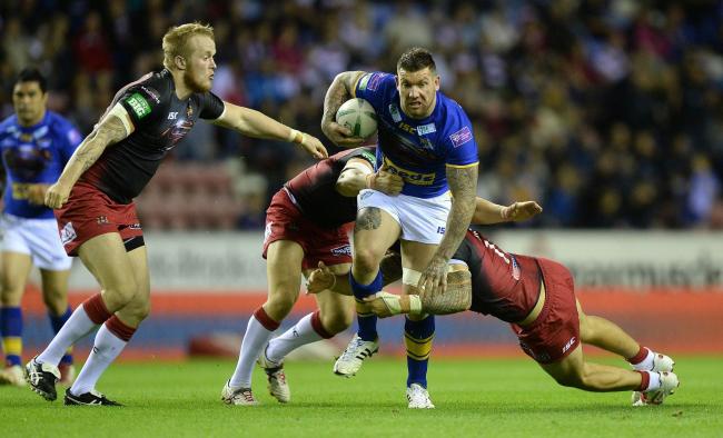 York City Knights assistant coach Brett Delaney is tackled by Wigan Warriors defenders while representing Leeds Rhinos. Picture: Martin Rickett/PA Wire
