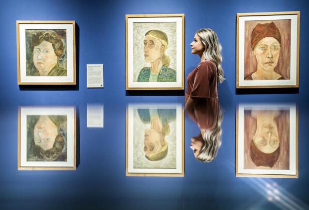 York Press: Millie Carroll is reflected in a glass display case, as she looks at works by artist Ray Strachey, during a photocall for the Beyond Bloomsbury: Life, Love & Legacy exhibition at the York Art Gallery.  Photos: AP
