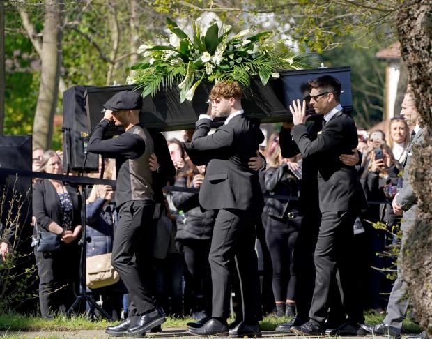 York Press: Max George (left) and Jay McGuiness of The Wanted (centre) carry the coffin at the funeral of their bandmate Tom Parker. (PA)