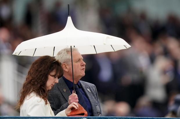 Racegoers shelter from the rain before the Sky Bet Race To The Ebor Jorvik Handicap during day one of the Dante Festival 2022 at York racecourse. Picture: PA