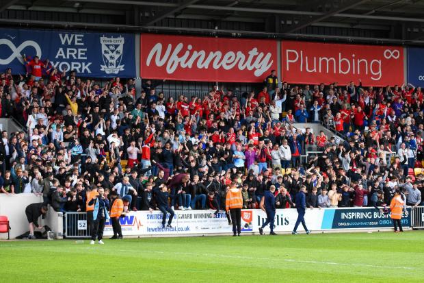 York City supporters in the South Stand celebrate the 2-0 Vanarama National League North play-off final victory over Boston United at the LNER Community Stadium. Picture: Tom Poole