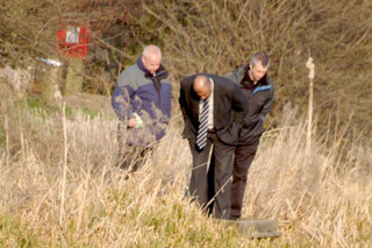 HUNTING FOR CLUES: Detectives at the scene after the body of Cai Guan Chen was found in the canal at Burn