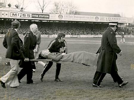 27/04/74: York City 1, Oldham 1 - Oldham defender Wood is carried off the pitch with a dislocated collar bone after colliding with Seal.