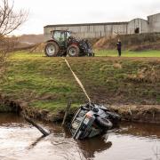 The recovered vehicle being removed from the River Esk near Glaisdale, North Yorkshire, after three men, trapped in a submerged 4×4 vehicle, were 