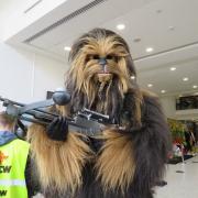 Chewbacca poses with a massive blaster at York Comic Con