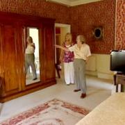 An mage from the film shows June Lloyd-Jones, with TV presenter Christine Talbot, taking a look at the wardrobe her brother, John Barry, used that is still in a bedroom of the Pavilion Hotel in Fulford, York