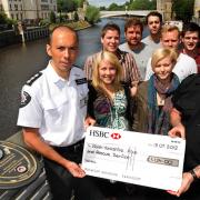 Friends of Richard Horrocks look on as a cheque for more than £1,000, raised from their naked calendar, is presented by Chloe Bowman, left front, and Abbi Horrocks, right front, to York Fire Station manager Paul Bennett and firefighter Paul Warnock